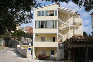 un edificio bianco con scale di fronte a una strada di Apartments by the sea Podgora, Makarska - 2615 a Podgora