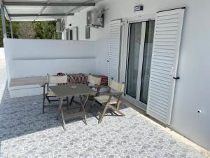 a patio with a table and chairs on a balcony at VILLA NOULI in Sarakiniko