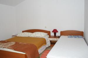 1 dormitorio con 2 camas y mesa con lámpara en Apartments by the sea Podgora, Makarska - 2624, en Podgora