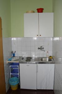 una cocina con armarios blancos y fregadero en Apartments by the sea Podgora, Makarska - 2624, en Podgora