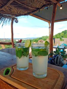 dos cócteles sentados en una tabla de cortar de madera en Kitesurf Hostal Ocean House-Santa Verónica, en Santa Verónica