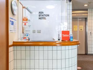 a counter in a hospital with a sign on the wall at Tabist Asa Station Hotel 