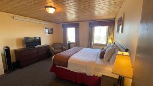 une chambre d'hôtel avec un lit et une télévision dans l'établissement Yosemite Gateway Motel, à Lee Vining