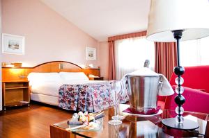 Habitación de hotel con cama y mesa con lámpara en Hotel Arumí, en Santa Eugènia de Berga