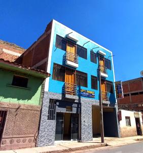 a blue building with balconies on a street at Hotel Everest in Pisac