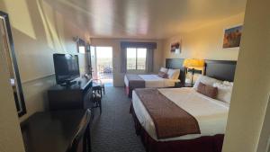 una camera d'albergo con due letti e una televisione di Yosemite Gateway Motel a Lee Vining