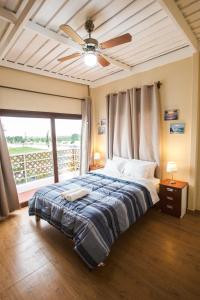 a bedroom with a bed with a ceiling fan at El Paraíso Eco Resort in Pisco