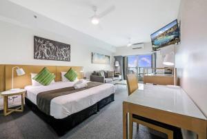 una camera d'albergo con un grande letto e un soggiorno di High-Rise Modern Oasis with Pool and City Views a Darwin