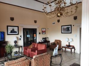 a living room with red chairs and a chandelier at Econo Lodge Inn & Suites Griffin North in Griffin