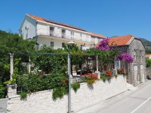 a house with flowers and plants on a wall at Apartments and rooms by the sea Slano, Dubrovnik - 2682 in Slano