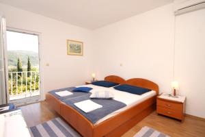 sypialnia z łóżkiem i dużym oknem w obiekcie Apartments and rooms by the sea Slano, Dubrovnik - 2682 w mieście Slano