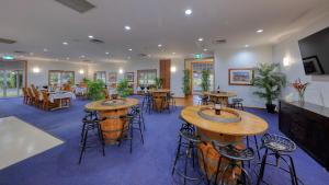 a restaurant with tables and stools in a room at Chinchilla Great Western Motor Inn in Chinchilla