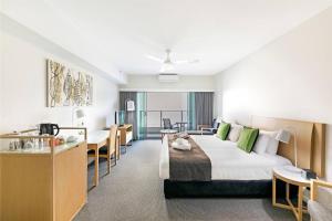 um quarto de hotel com uma cama grande e uma escrivaninha em King Balcony Studio at Resort Style Darwin Stay em Darwin