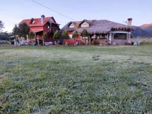 a house with a grass field in front of it at Refugio de Montaña Huerta Sacha in Chaupi