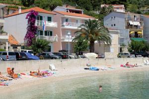 eine Gruppe von Menschen, die am Strand in der Nähe des Wassers liegen in der Unterkunft Apartments by the sea Podgora, Makarska - 11432 in Podgora