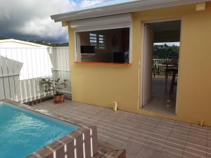 a house with a swimming pool and a patio at VILLA LINEDDY/ZINNIA in Quartier la Fleury Guiné