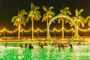um grupo de pessoas em uma piscina à noite em Coral Ocean Resort em Saipan