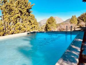 a swimming pool with blue water and trees and mountains at Welcoming villa in Torres with private pool in Torres