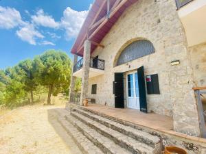 ein Steingebäude mit einer Tür und einer Veranda in der Unterkunft Welcoming villa in Torres with private pool in Torres