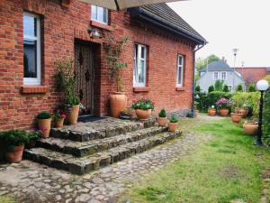 a brick house with potted plants in front of it at Historical holiday home in Mielenko 400 m from the sea in Mielenko