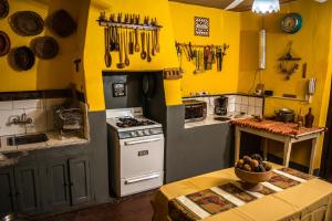 a kitchen with yellow walls and a stove and a table at LA PACHAMAMA in San Juan