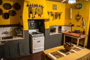 cocina con paredes amarillas, fogones y mesa en LA PACHAMAMA en San Juan