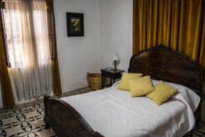 Un dormitorio con una cama con almohadas amarillas. en LA PACHAMAMA en San Juan