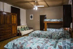 1 dormitorio con 2 camas y sofá en LA PACHAMAMA en San Juan