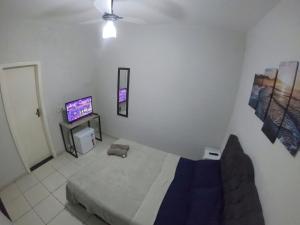 a bedroom with a bed and a flat screen tv at Soul do Mar Hostel in Cabo Frio