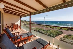 a balcony with chairs and a view of the ocean at Canal Rocks Beachfront Apartments in Yallingup