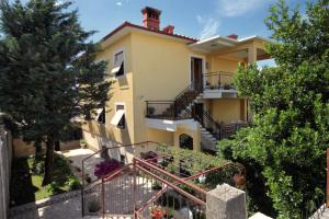 une maison jaune avec des escaliers et un balcon. dans l'établissement Apartments with a parking space Novi Vinodolski - 2416, à Novi Vinodolski