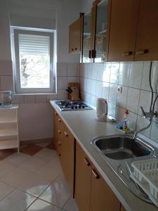 une cuisine avec évier et cuisinière ainsi qu'une fenêtre dans l'établissement Apartments with a parking space Novi Vinodolski - 2416, à Novi Vinodolski