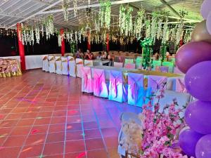 a banquet hall with purple and purple balloons and tables at Hotel Verde Menta in San Gil