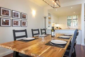 Una mesa de comedor con sillas y una botella de vino. en Villa Legato, en Pokolbin