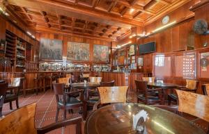 a restaurant with wooden walls and tables and chairs at Hotel MAURY in Lima
