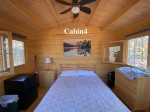 a bedroom with a bed and a ceiling fan at Algonquin Madawaska Lodge Cottage Glamping Cabins in Madawaska