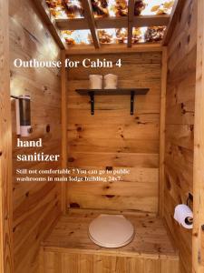 Baño con aseo en una cabaña de madera en Algonquin Madawaska Lodge Cottage Glamping Cabins, en Madawaska