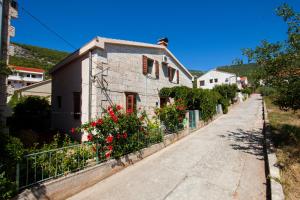 una casa con flores al lado de una calle en Apartments by the sea Komiza, Vis - 2450, en Komiža