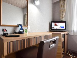 a desk with a computer and a mirror at Hotel WBF Kushiro in Kushiro