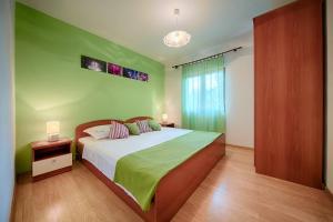 a bedroom with a large bed with green walls at Apartments by the sea Komiza, Vis - 2447 in Komiža