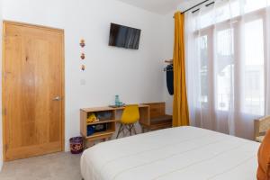 a bedroom with a bed and a door and a desk at Santa Cecilia Hotel in Oaxaca City