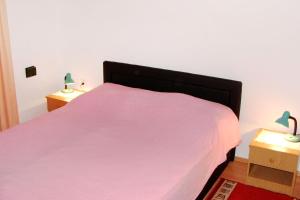a bedroom with a pink bed with two night stands at Apartments by the sea Milna, Vis - 2461 in Rukavac