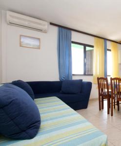 a living room with a blue couch and a table at Apartments by the sea Milna, Vis - 2461 in Rukavac