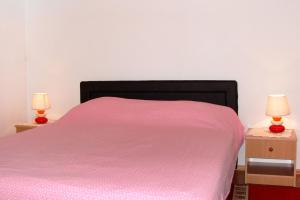 1 dormitorio con 1 cama rosa y 2 mesitas de noche en Apartment Milna 2461c, en Rukavac