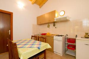 a kitchen with a table and a stove top oven at Apartment Milna 2461c in Rukavac