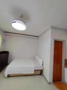 a small room with a bed and a light at 29 Palm's Panglao Suites in Panglao