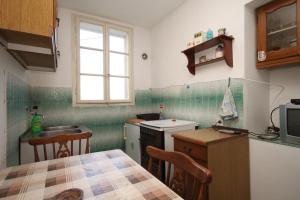 a small kitchen with a sink and a table in it at Apartments with a parking space Podselje, Vis - 2462 in Vis