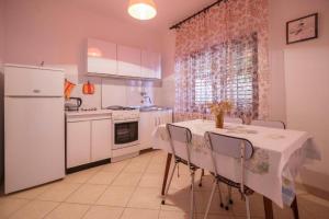 een keuken met een tafel met stoelen en een koelkast bij Apartments with WiFi Komiza, Vis - 2420 in Komiža +20 foto's