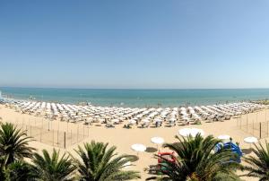 una playa con muchas sombrillas y el océano en Hotel President, en Silvi Marina