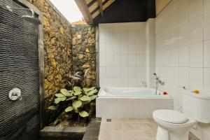 a bathroom with a toilet and a bath tub at Gora House Bali in Ubud